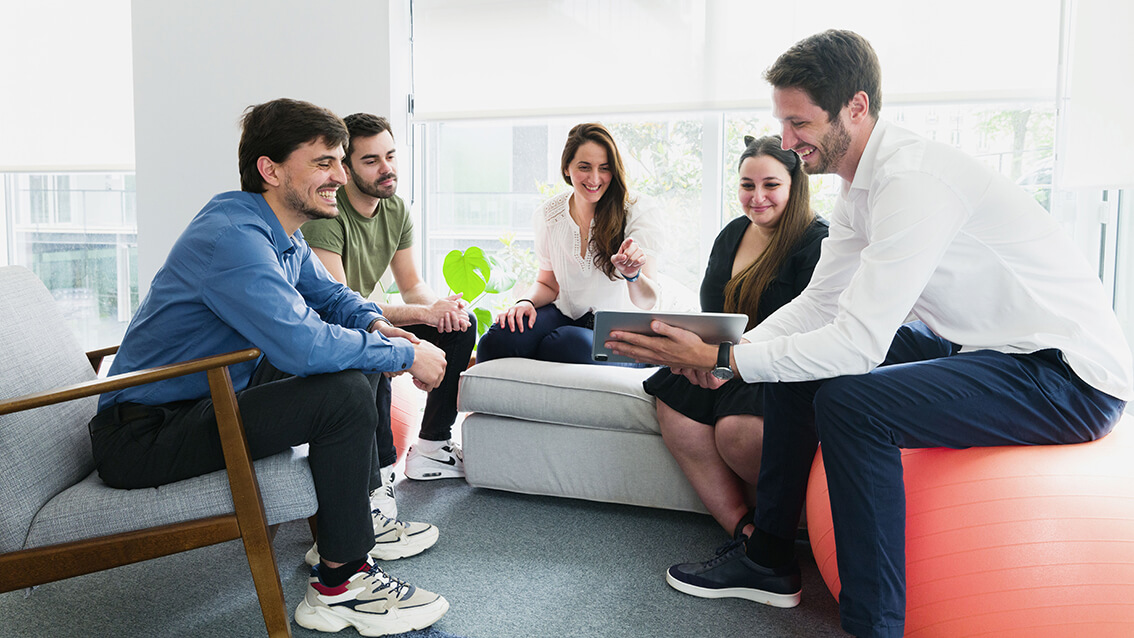 Cinq personnes autour d'une tablette en train de discuter